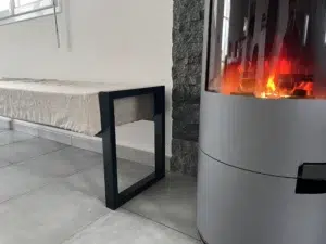 Banquette et poêle à bois moderne allumé.