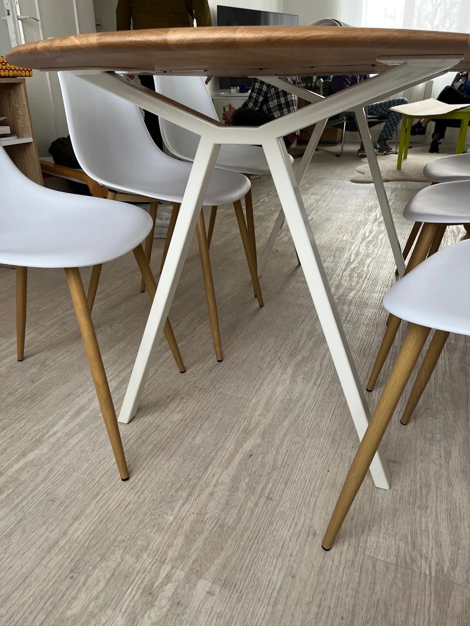 Chaises blanches autour d&#039;une table en bois.