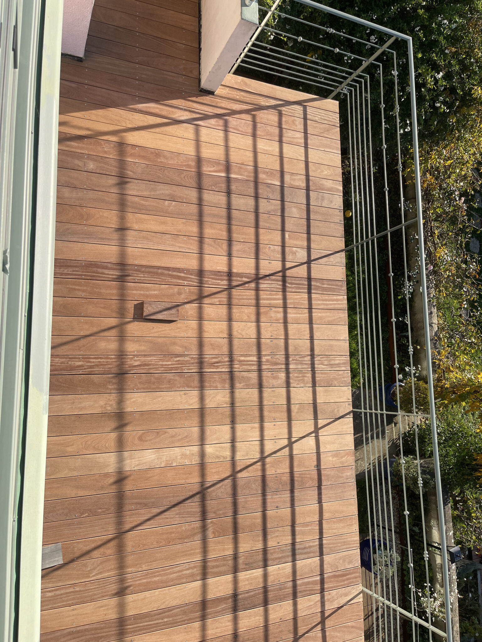 Terrasse en bois avec ombres métalliques.