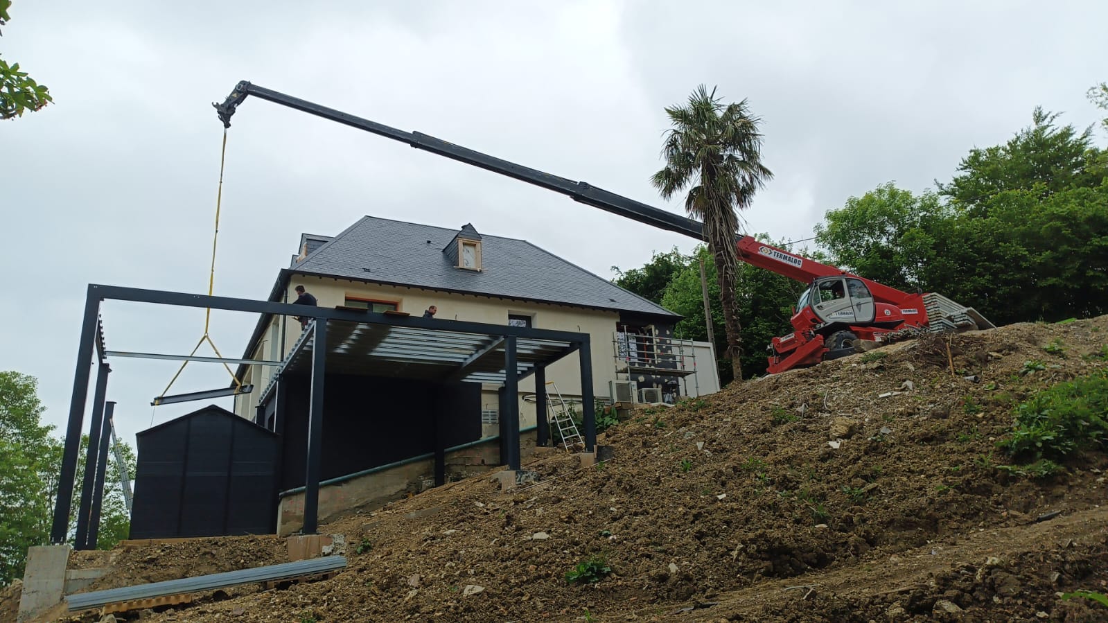 Construction de véranda avec une grue rouge.