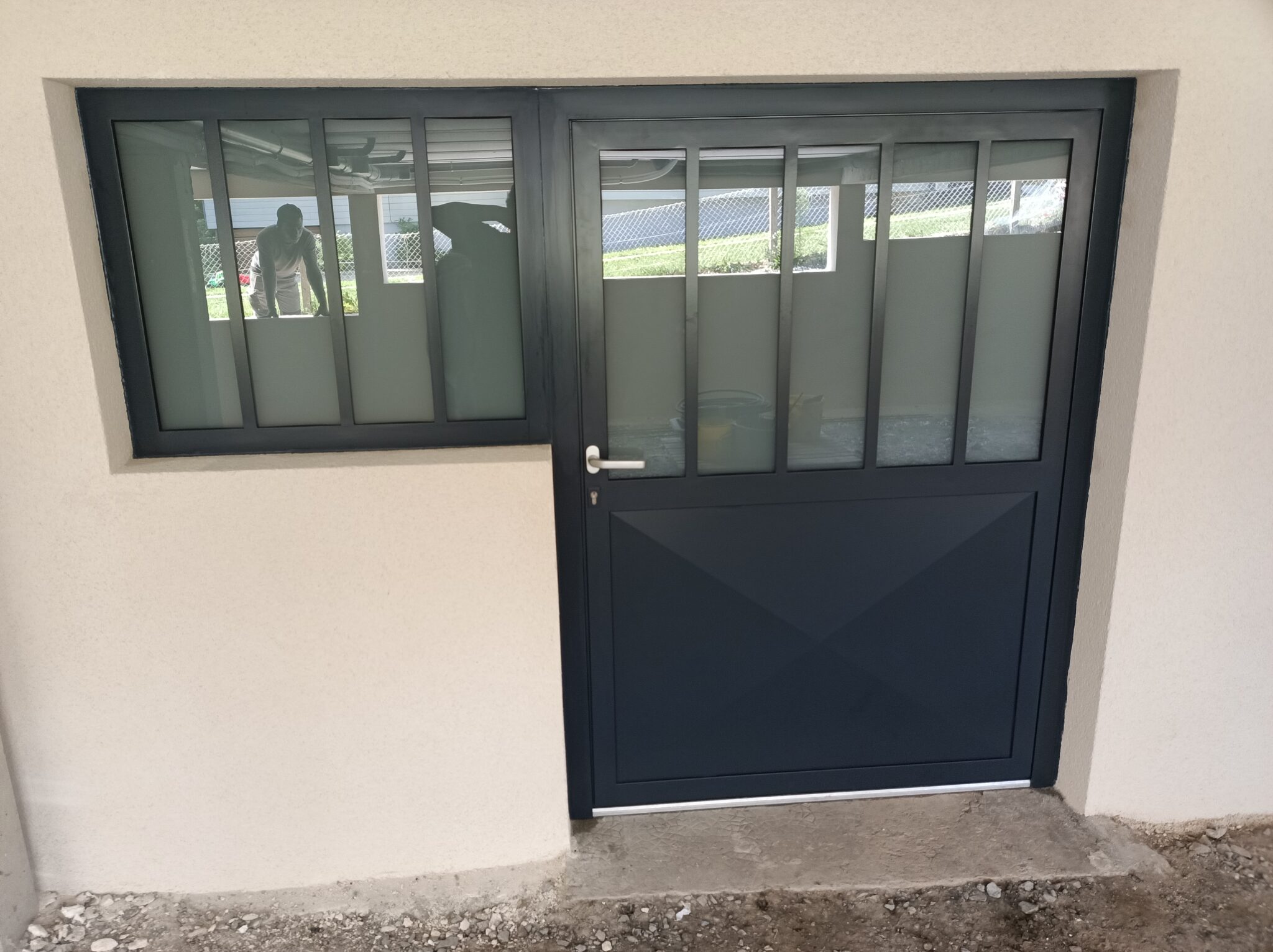 Porte avec fenêtre noire et murs clairs.